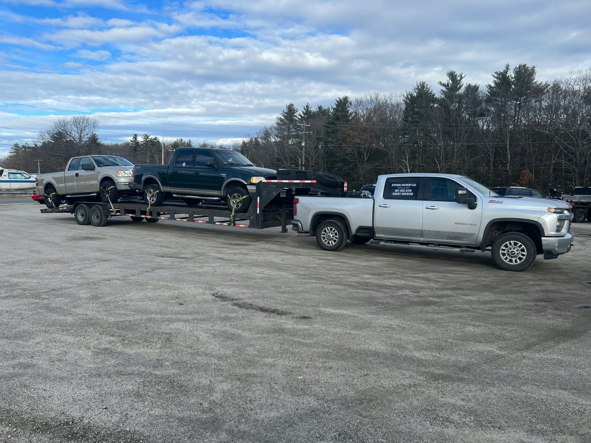 a tow truck towing a silver truck in a parking lot